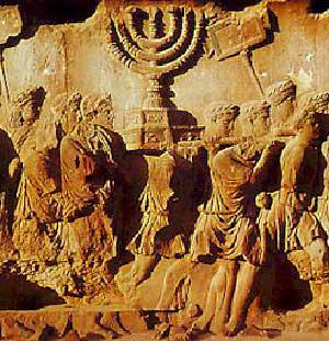 Bas relief représentant l’Arche d’Alliance (surmontée de la menorah) portée fièrement par le Peuple Juif comme signe de son entente éternelle avec le dieu unique